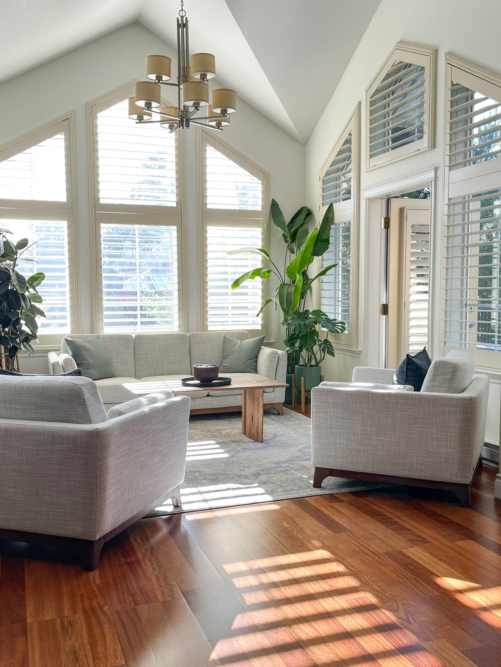 Living room with tall windows and sun across the floor
